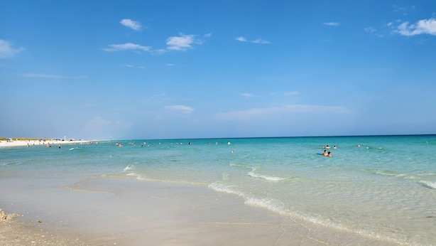 Uma praia com águas azul-claras e uma faixa de areia.
