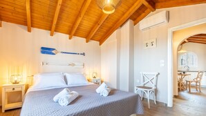 Een slaapkamer met een bed, een stoel, een bureau en een eethoek.