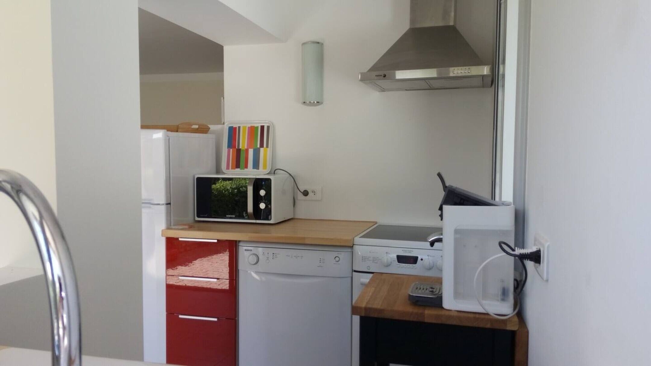 A compact kitchen with a microwave, toaster, and dishwasher.
