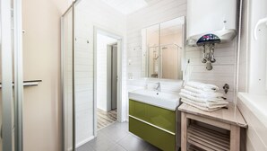 A modern bathroom with a white vanity, a large mirror, and a shower area. - 2 bedroom amazing home in Ruhla (Ruhla)