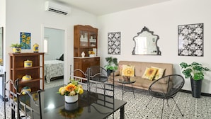 A room with a dining table, chairs, a sofa, a cabinet, and a ceiling fan. - Holiday Home 'Marisol' with Shared Pool, Wi-Fi & Air Conditioning (Puente Genil)