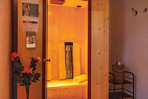 Una sauna de madera con un banco, una toalla y una cesta.