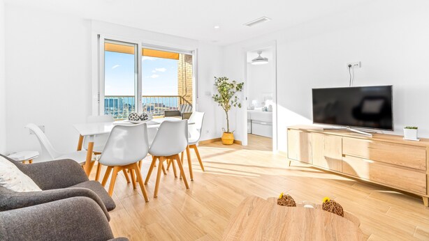 Un salon moderne comprenant un coin repas, un téléviseur et un balcon avec vue.