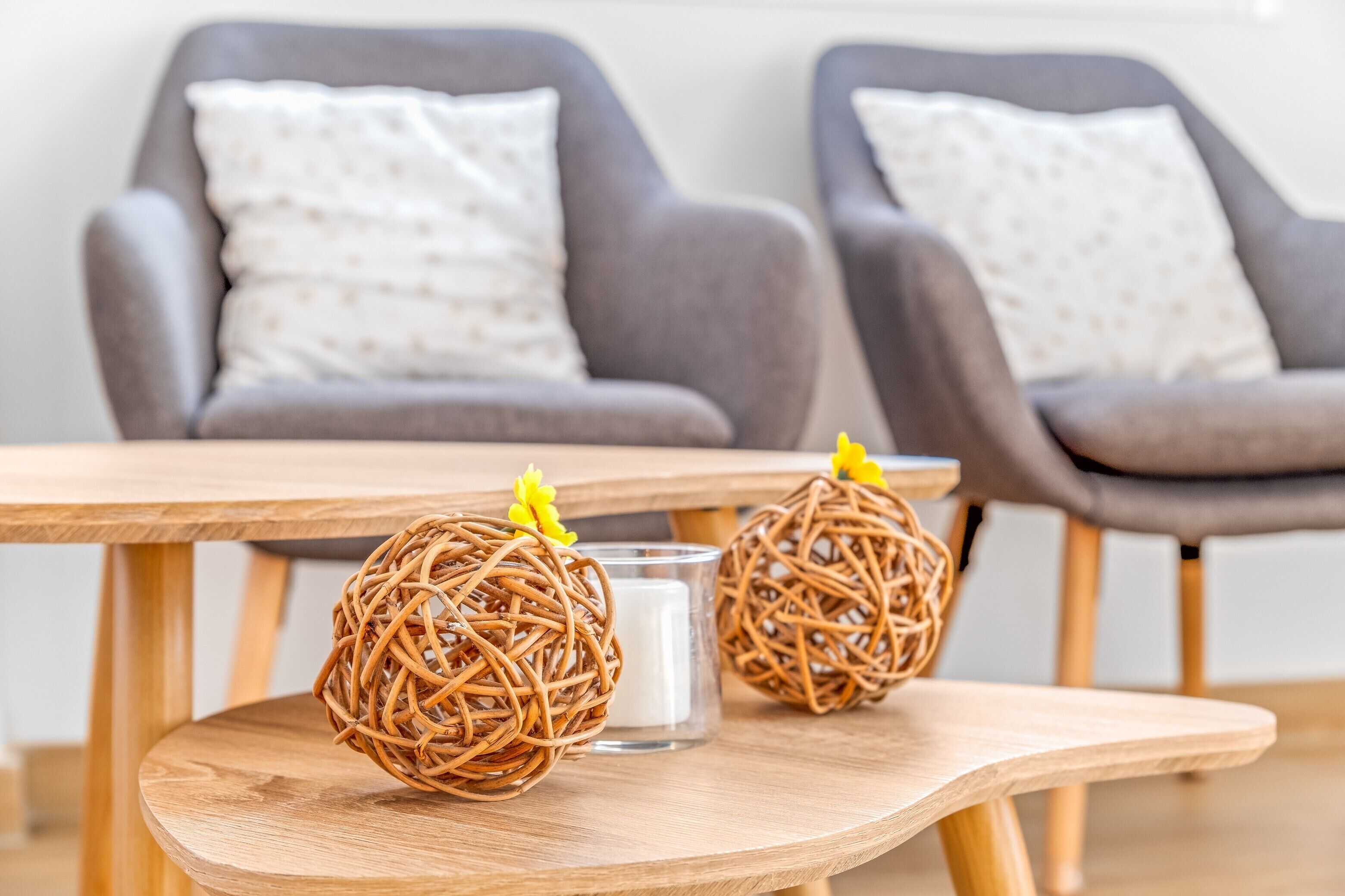 A wooden table with two wicker balls and a candle.