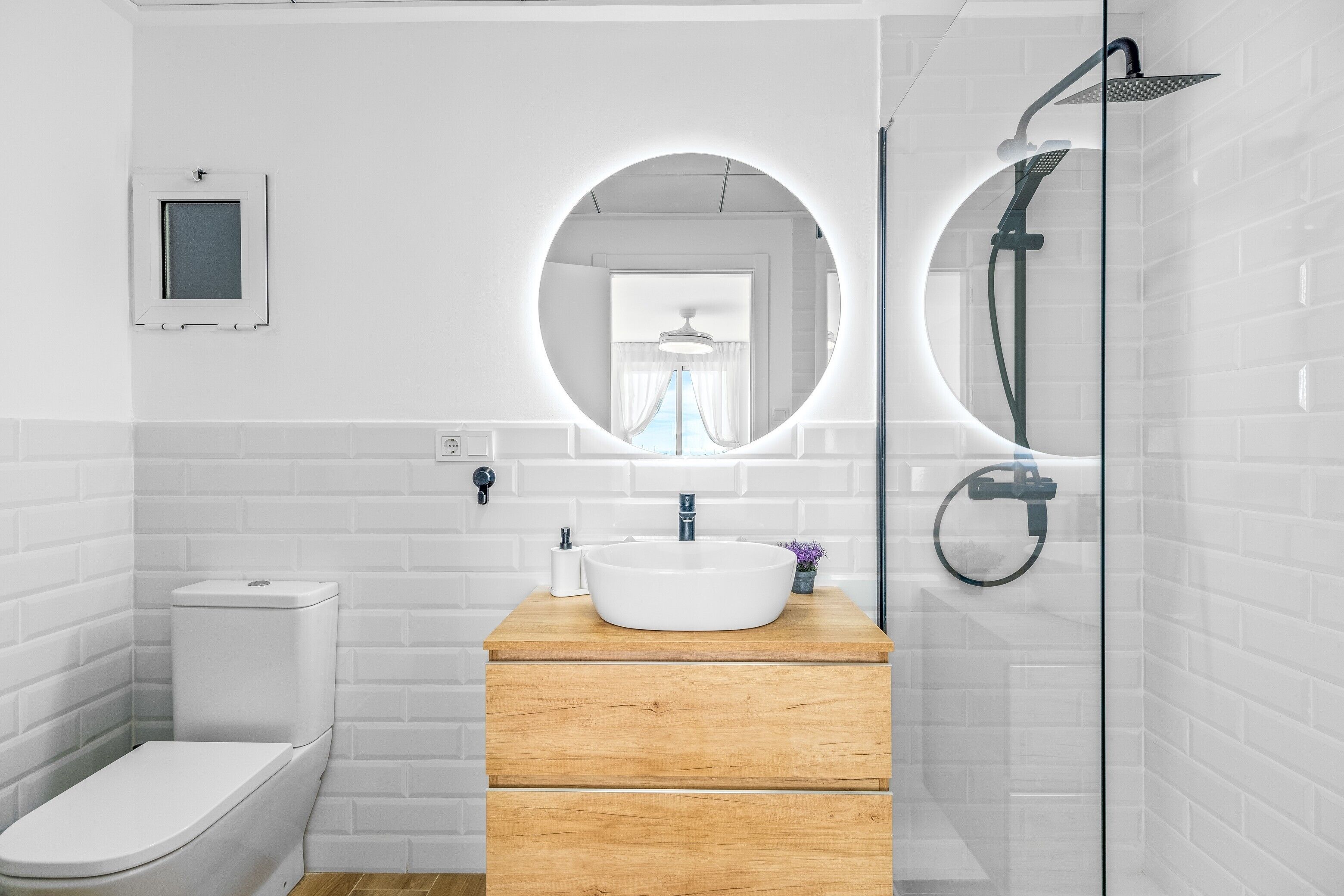 Une salle de bain moderne équipée de toilettes, d’un lavabo et d’une douche.