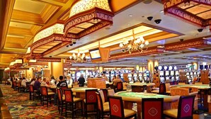A casino with multiple gaming tables and chairs, a patterned carpet, and ornate ceiling decorations. - Beach house, 1.5 blocks from beach, 3bd, 3 bath (gulfport)