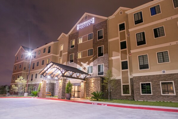 A Staybridge Suites hotel with a covered entrance, multiple floors, and a well-lit facade.