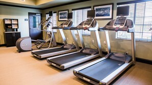 A fitness center with treadmills, a stationary bike, and a weight bench. - Close to TU | Modern Suite + Heated Outdoor Pool (Austin)