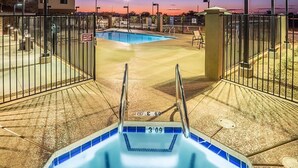 Zona de piscina con hidromasaje, rodeada por una valla y un portón.