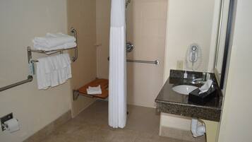 Une salle de bain avec douche, toilettes et lavabo.