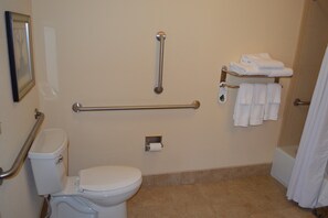 A bathroom with a toilet, grab bars, a towel rack, and a shower curtain. - Accessible 2-BR Suite w/ Tub & 2 Bathrooms (Oconomowoc)