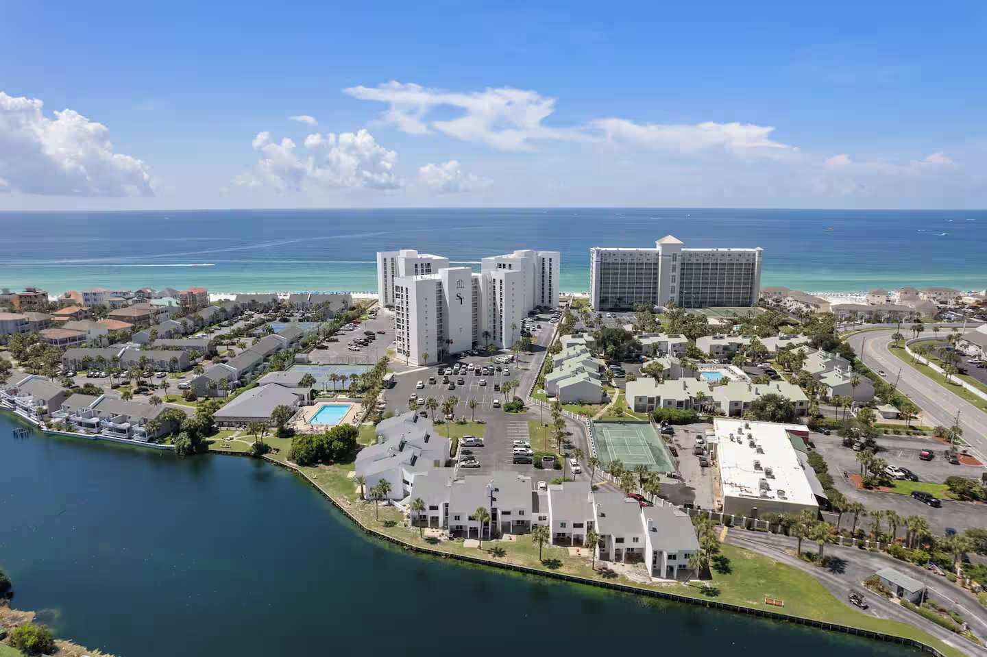 A coastal resort area with high-rise buildings, a marina, and a golf course.