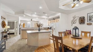 Une cuisine spacieuse avec un îlot central, une table à manger en bois et des chaises.