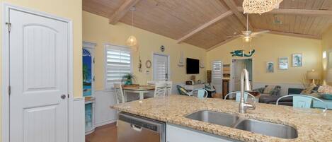 A kitchen with granite countertops, stainless steel appliances, and a wooden ceiling.
