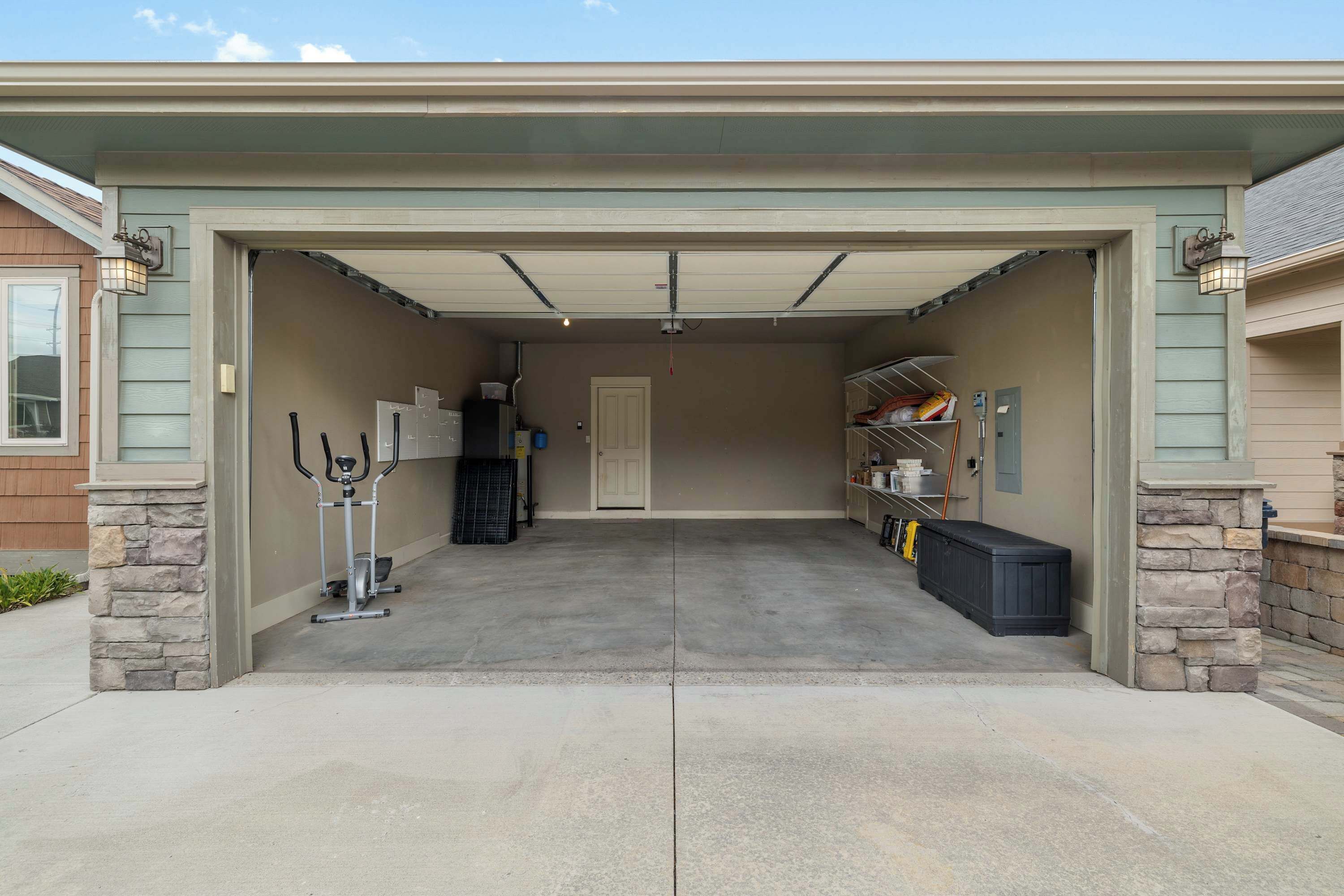 Eine Garage mit Betonboden, einer Tür und einem Regal mit verschiedenen Gegenständen.
