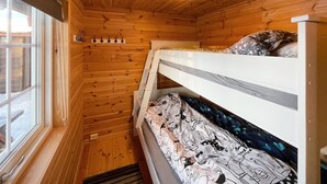 A small cabin with wooden walls and a bunk bed.