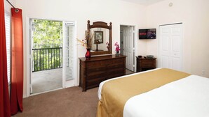 A bedroom with a bed, dresser, mirror, and a TV on the wall. - Tropical 2 BDR Condo in Brand New Resort Community (Kissimmee)