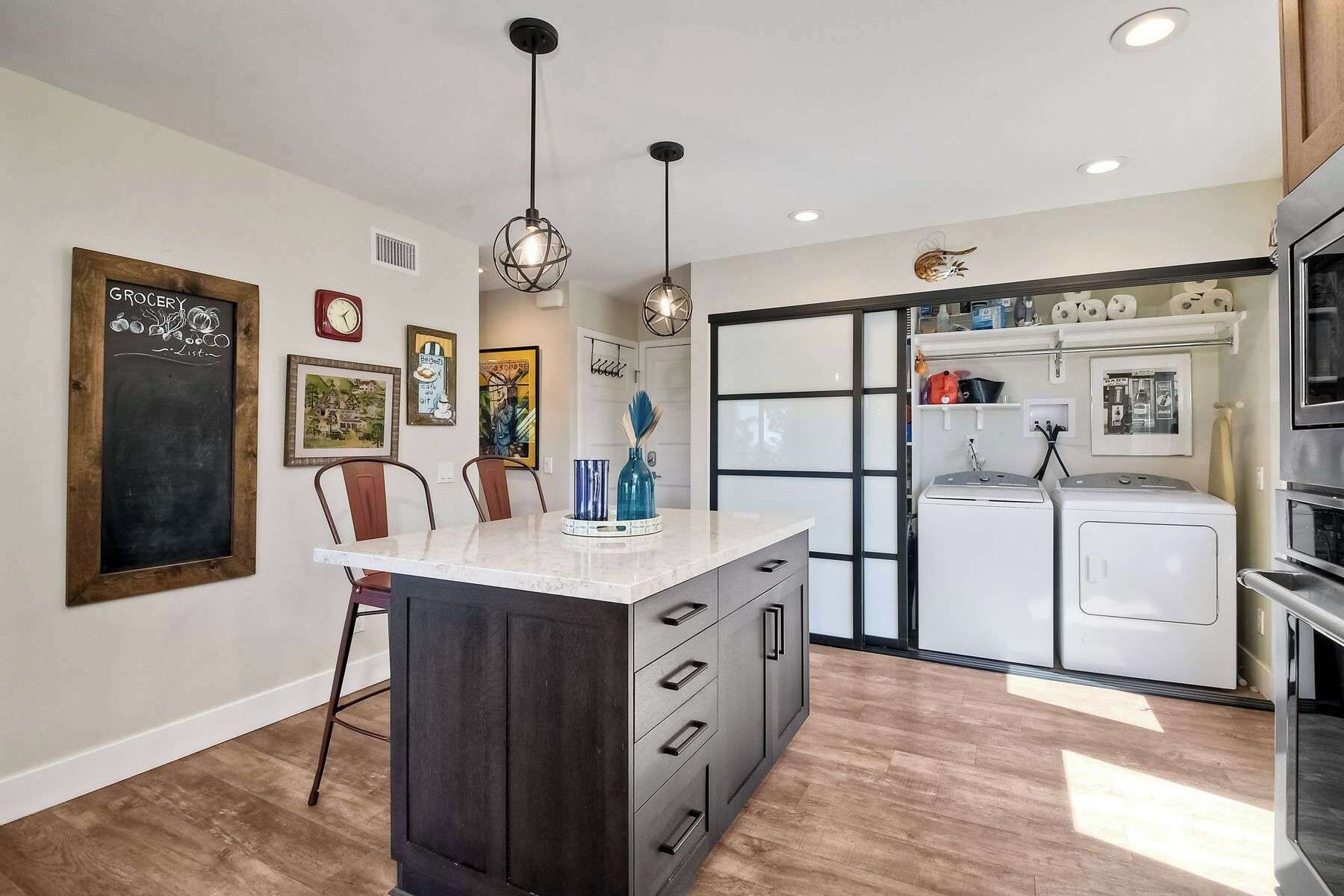 A modern kitchen with a central island, built-in appliances, and decorative wall art.