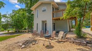 Une maison à deux étages dotée d’un porche abrité, d’un espace salon extérieur et d’un barbecue.