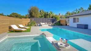 Patio trasero con piscina, sillas de descanso y un pequeño espacio de terraza.
