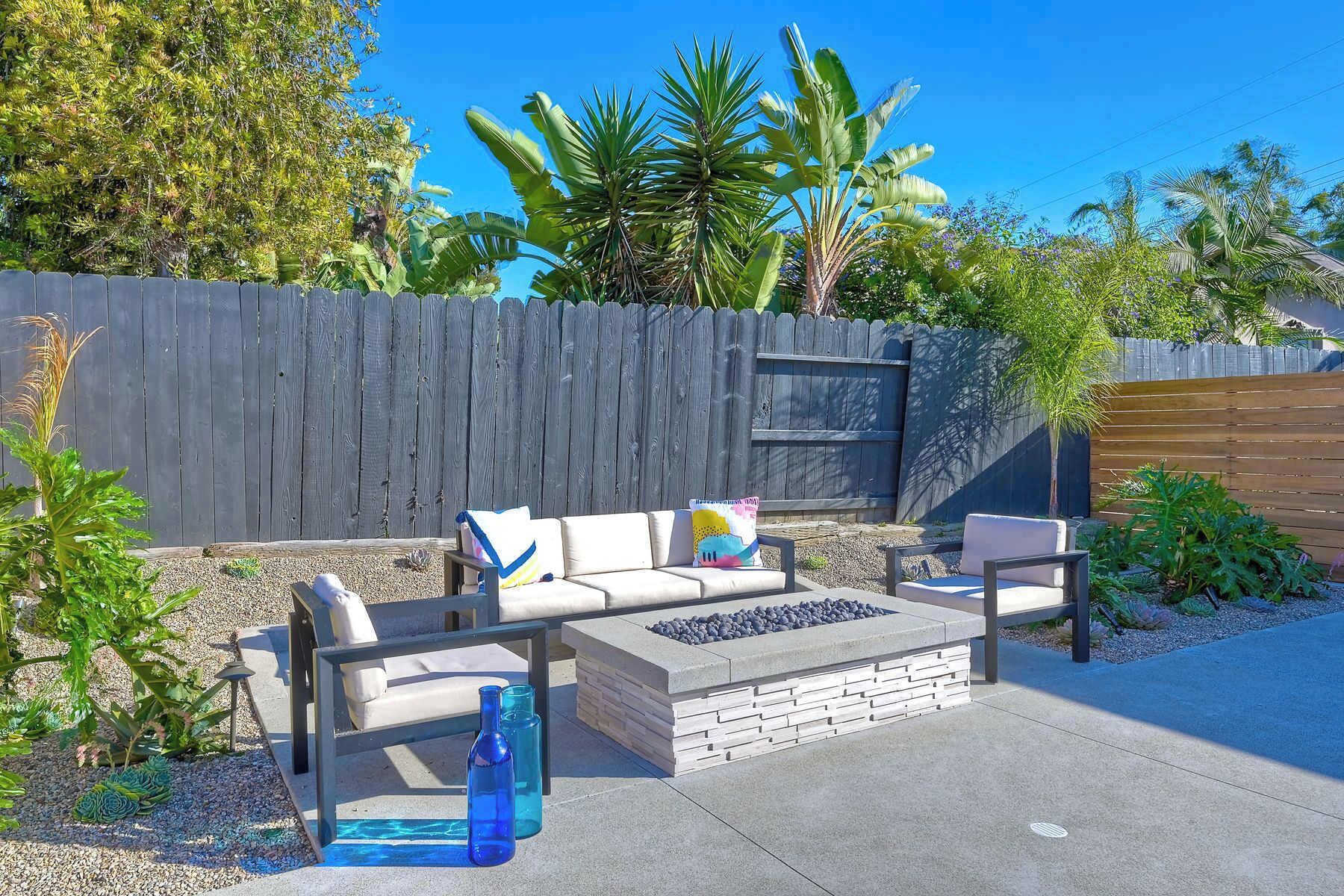 Une terrasse extérieure aménagée avec un ensemble de canapés, une table basse et des coussins décoratifs.