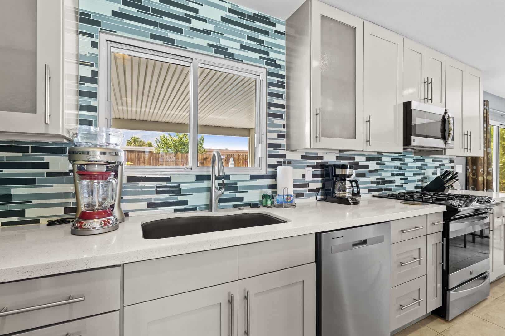 A modern kitchen with a stainless steel refrigerator, a built-in oven, and a microwave.