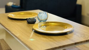 A dining table with two gold plates and a decorative glass vase. - Cozy apartment near to the center. (Guatavita)