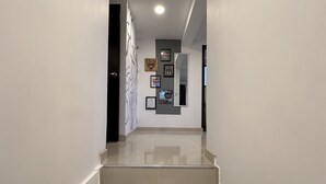 A clean, modern hallway with a staircase leading to a door. - Cozy apartment near to the center. (Guatavita)