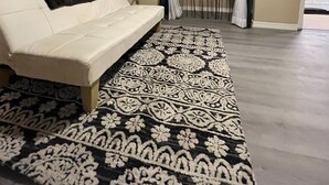 A living room with a white sofa, a patterned rug, a large mirror, and a view of a balcony. - Welcome to the River House! Bright peaceful desert/river home.  (Parker)