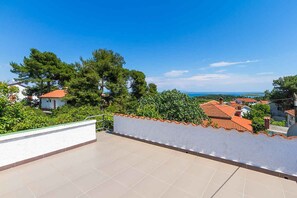 A rooftop terrace with a clear view of the sea and surrounding houses.
