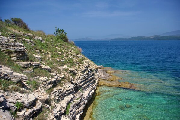 Un paysage côtier caractérisé par des falaises rocheuses et une mer d’un bleu limpide.