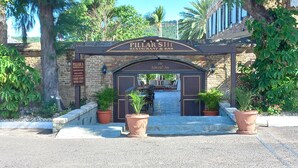 The entrance to Pillar's Restaurant & Bar, featuring a brick archway with potted plants on either side. - A Blissful Carib/n Getaway! Work or Leisure, 15 mins to Beaches & Restaurants. (Saint John's)