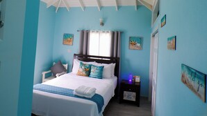 A bedroom with a bed, a nightstand, a ceiling fan, and wall art. - A Blissful Carib/n Getaway! Work or Leisure, 15 mins to Beaches & Restaurants. (Saint John's)