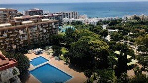 A high-rise hotel with multiple balconies, a swimming pool, and a view of the sea. - Holidays2Arroyo de la Miel Hercules (Benalmádena)