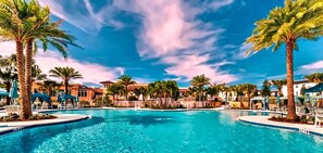 A swimming pool with palm trees and a clear sky. - 7BR Disney Villa - Heated Pool + Cinema + Game Rm + SpiderVerse Room (Four Corners)