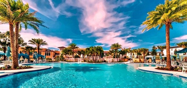 A swimming pool with palm trees and a clear sky. - 7BR Disney Villa - Heated Pool + Cinema + Game Rm + SpiderVerse Room (Four Corners)