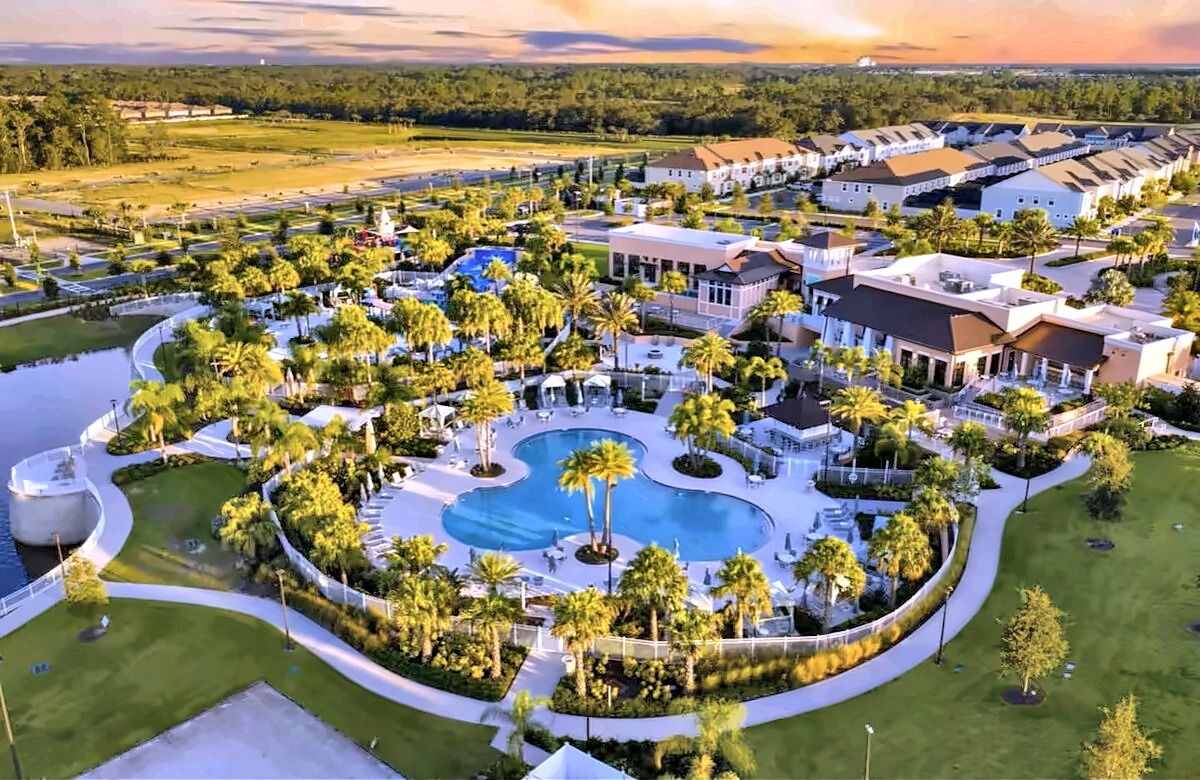 Aerial view of Solara Resort's clubhouse, grand pool and water park at sunset.
