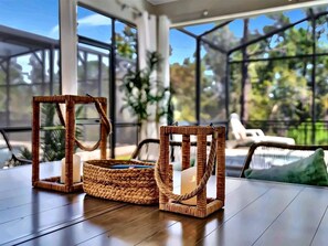 Lanai dining details: rattan lanterns on the outdoor table with the heated pool 