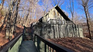 A wooden bridge leading to a cabin with a sloped roof, surrounded by trees. - 4 min Beech Mtn. Gem: Cabin Retreat near Slopes & Trails 
Pet friendly (Beech Mountain)