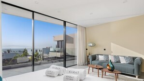 A modern hotel room with a large balcony, a sofa, a coffee table, and a bed with towels. - KARAT Villa Serendibida (Playa Paraiso)