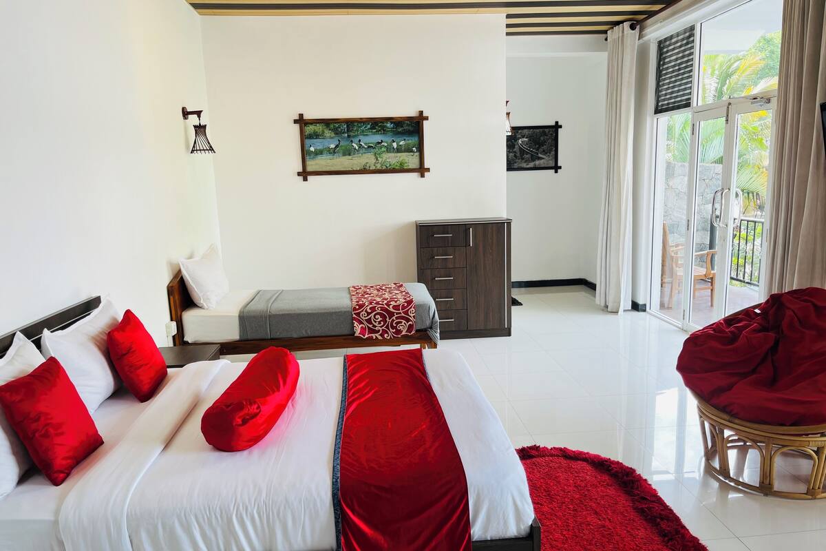Un dormitorio con cama, cómoda, silla y vistas al exterior.