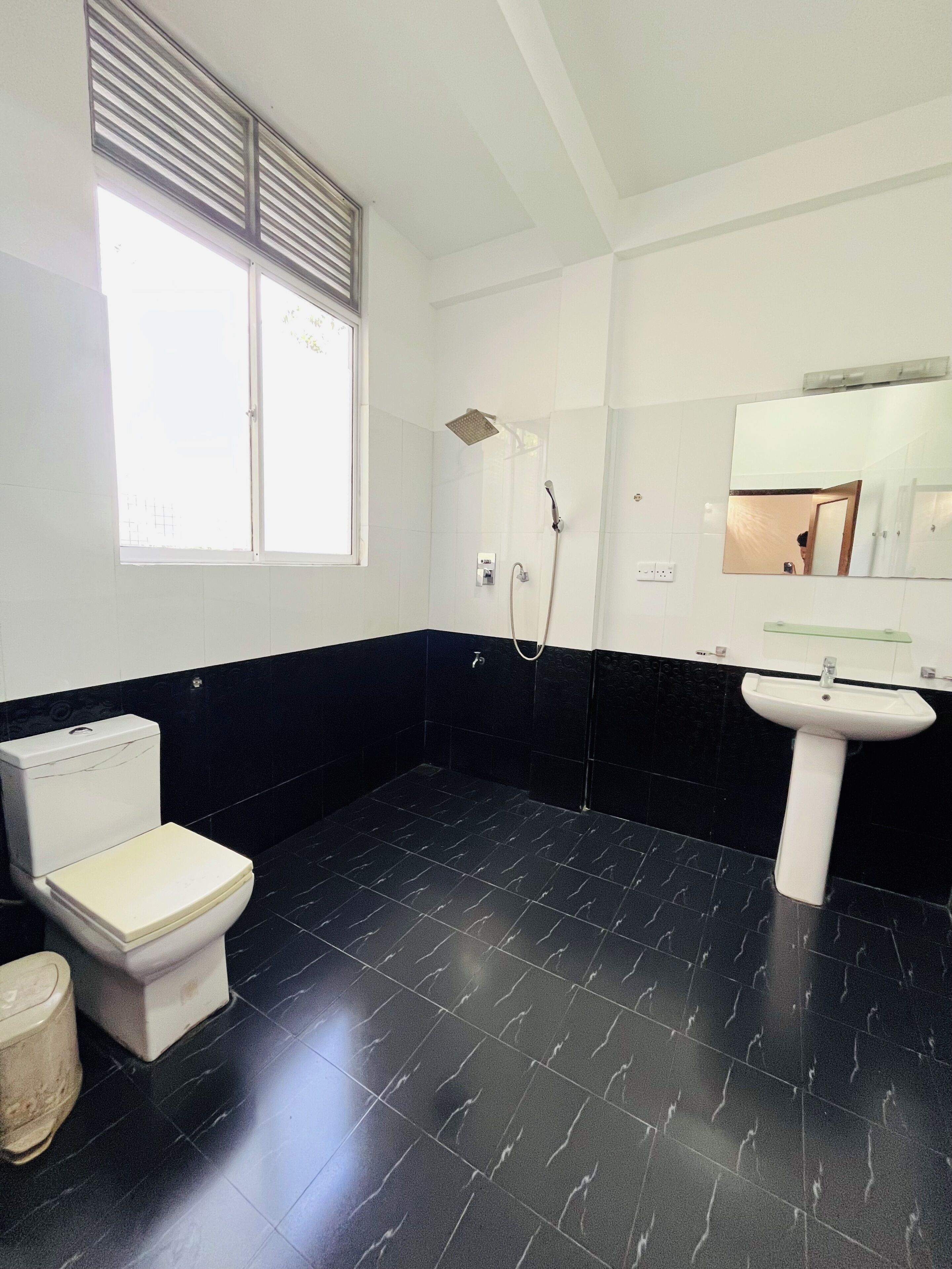 A bathroom with a toilet, sink, and shower.