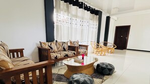 A modern living room with a sofa set, a coffee table, and a rug. - HERITAZ VILLA ELLA (Ella)