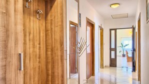 A wooden door with a metal handle and a metal hook.