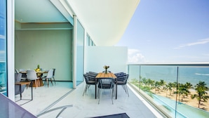 A modern balcony with a dining area, a seating area, and a view of the beach and ocean. - NEW Beachfront Marítima Condos 2 Pools (Nuevo Nayarit)