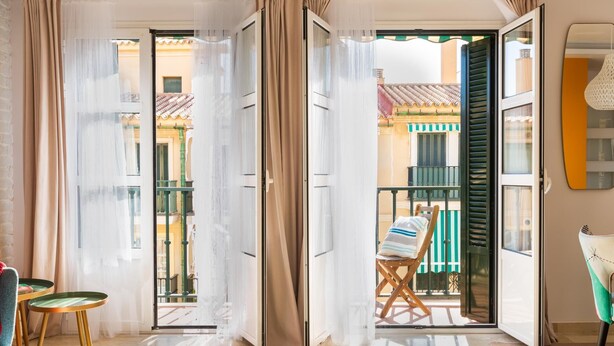 A room with a balcony, a chair, and a table. - Central and bright apartment with balconies (Málaga)