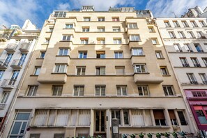 Ein mehrstöckiges Gebäude mit einer symmetrischen Fassade, großen Fenstern und Balkonen.