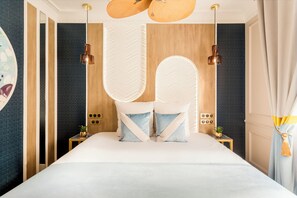 Une chambre d’hôtel moderne dotée d’un grand lit, de touches de décoration en bois et d’un design de plafond original.