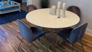 A dining area with a round table, four chairs, a mirror, and a ceiling light fixture. - Cozy house in Bishop District (Dallas)