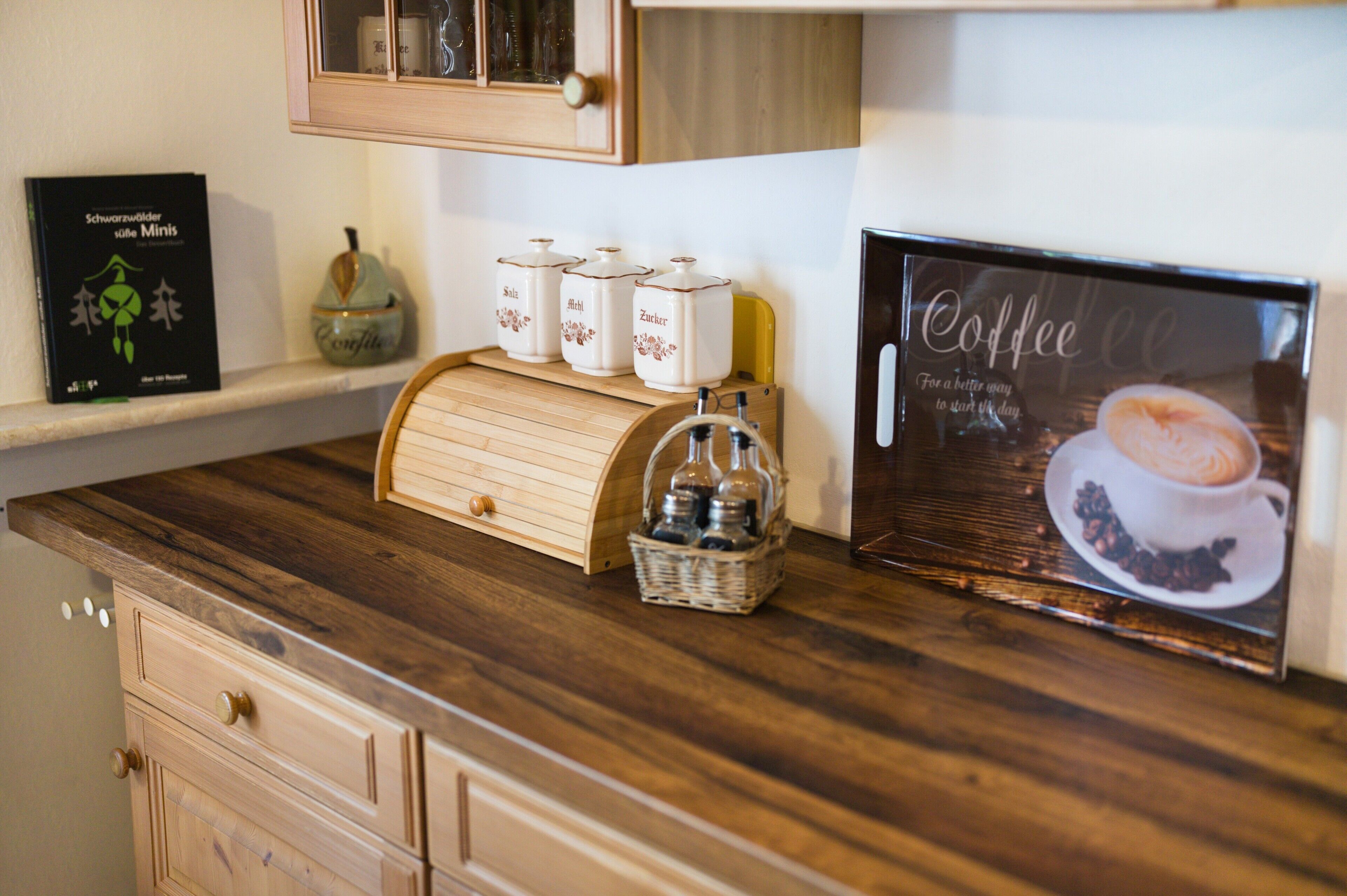 Een keukentafel met koffie-thema, inclusief een koffieboek, een koffiekop en een koffiezetapparaat.